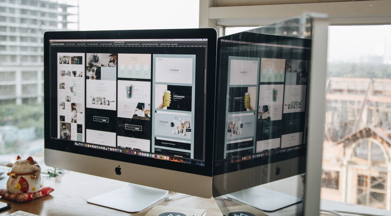 Deux écrans sur un bureau, mettant en valeur le web design dans un environnement de bureau moderne.